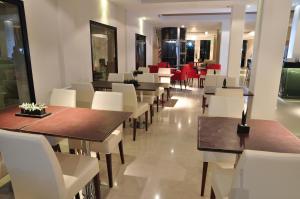 a restaurant with wooden tables and white chairs at San Martin Plaza Hotel in Villa Elisa