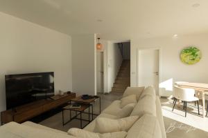a living room with a couch and a flat screen tv at Casa Kiara Silvercoast in Nadadouro