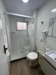 a bathroom with a shower and a toilet and a sink at Loft Studio no Kobrasol in São José +15 photos