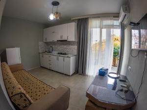 a living room with a couch and a table and a kitchen at Emma's Guest house in Gonio