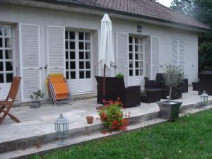 a patio with an umbrella and a chair and an umbrella at La Petite Trolière in Orval