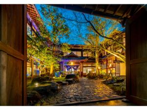 an open door to a house with a cobblestone yard at Shiseki Ryokan Kagetsu Taishoukan - Vacation STAY 48529v in Takeo
