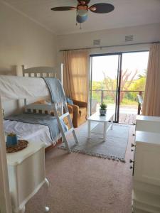 a bedroom with a bunk bed and a sliding glass door at Nineve Retreat in Wilderness