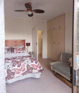 a bedroom with a bed and a ceiling fan at Nineve Retreat in Wilderness