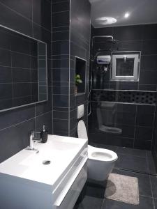 a bathroom with a white sink and a toilet at Modern Appartement Noord Jan Thiel #2 in Willemstad +24 photos