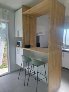 a kitchen with a counter and two stools in it at Gaby villa in Capesterre