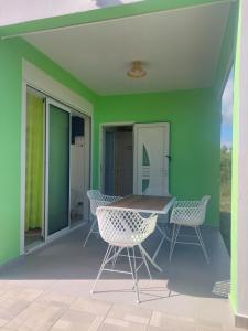 a patio with a table and chairs on a green wall at Gaby villa in Capesterre