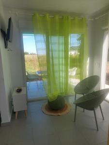 a living room with a table and chairs and a window at Gaby villa in Capesterre