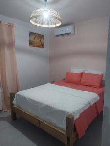 a bedroom with a bed with red and white sheets at Gaby villa in Capesterre