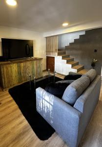a living room with a couch and a staircase at Rincón de Arístides in Mendoza