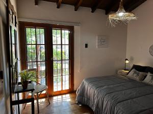 a bedroom with a bed and a glass door at Rincón de Arístides in Mendoza