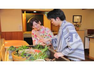 稲取にあるInatori Tokai Hotel Yuen - Vacation STAY 48865vの台所の料理を作る男女