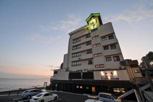 稲取にあるInatori Tokai Hotel Yuen - Vacation STAY 48865vの時計付きの高層ビル