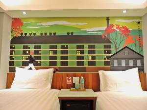 a bedroom with two beds and a mural of a building at Meci Hotel in Hualien City