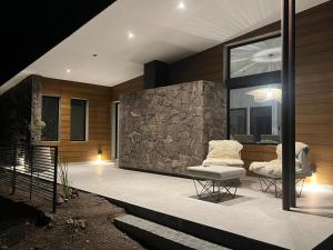 a patio with two chairs and a stone wall at Ayres Lodge Vista Calma Potrerillos in Potrerillos