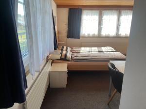 a small bedroom with a bed and a window at Ferienwohnung Inauen in Appenzell