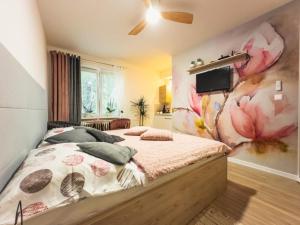 a bedroom with a bed with a flower wall at Apartmán Poprad Centrum in Poprad