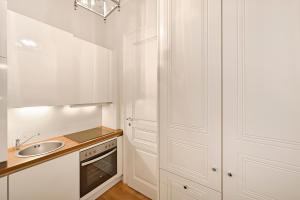 a kitchen with white cabinets and a sink at 6 rooms Naschmarkt in Vienna +175 photos