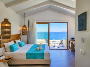 a bedroom with a bed with a view of the ocean at Zoe Boutique Hotel in Balíon