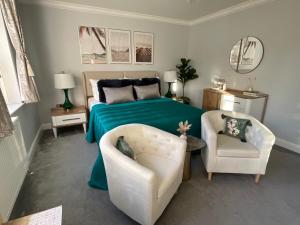 a bedroom with a green bed and two chairs at Jubilee Mews in London