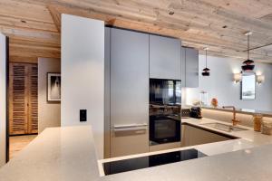 una cucina con elettrodomestici bianchi e soffitti in legno di Antarès MIRA 001 - deluxe apartment ski inski out a Méribel