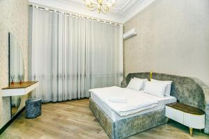 バクーにあるApartment Nizami 93のベッドとソファのあるホテルの部屋
