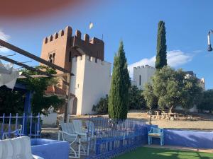 阿尔甘达·德尔·雷伊Torre Calera的一座带椅子的建筑,前面有栅栏
