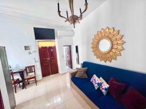 a living room with a blue couch and a mirror at Sunset Suite - Center of Mykonos in Mýkonos City