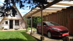 ein rotes Auto, das vor einem kleinen Haus parkt in der Unterkunft Casa Alpina Acantilados in Mar del Plata