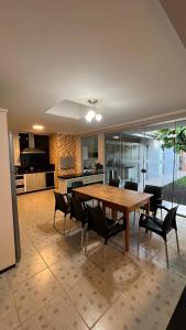 a kitchen and dining room with a wooden table and chairs at Pátio Musical Fortaleza in Foz do Iguaçu