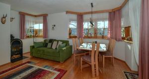 a living room with a green couch and a table at Ferienwohnung Wassermann in Wenns +38 photos