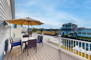 a deck with a table and chairs and an umbrella at South Bethany --- 106 Brandywine Drive in Bethany Beach