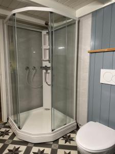 a shower stall in a bathroom with a toilet at Det lille huset i Slipveien in Bud