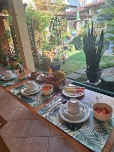 a table with plates and bowls of food on it at Suítes Jardim dos Sonhos in Ubatuba