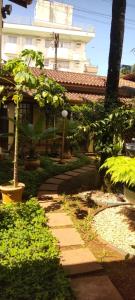 a garden with a walkway in front of a building at Suítes Jardim dos Sonhos in Ubatuba