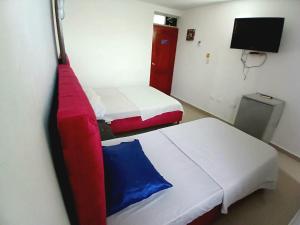 a room with two beds and a flat screen tv at hotel interamericano in Barranquilla