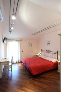 a bedroom with a red bed and a desk at Agriturismo Tonutti in Tavagnacco