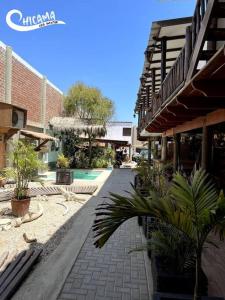 a walkway in a courtyard with plants and a building at Casa frente al mar playa Chicama, Puerto Malabrigo in Puerto Chicama +8 photos