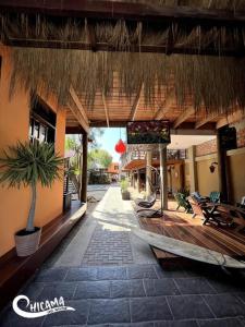 a patio with a straw umbrella and a tv on a building at Casa frente al mar playa Chicama, Puerto Malabrigo in Puerto Chicama