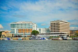 a group of boats in the water near buildings at Hotel Delta 3 in Tulcea
