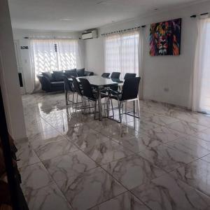 a dining room with a table and chairs on a marble floor at Naturaleza Necochea in Necochea