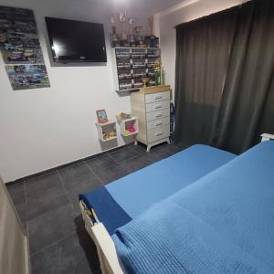 a bedroom with a blue bed and a tv at Naturaleza Necochea in Necochea