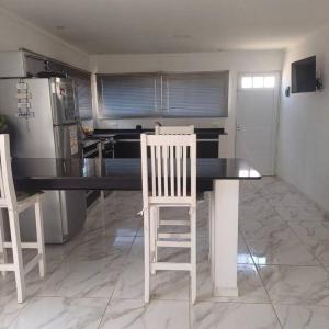 a kitchen with a table with two chairs and a refrigerator at Naturaleza Necochea in Necochea +9 photos