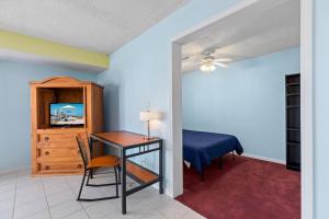 a bedroom with a desk and a bed and a table at 118 E Whiting St B Side in South Padre Island +26 photos