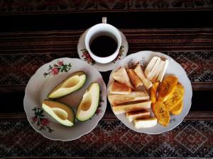 a table with two plates of food and a cup of coffee at INCA COFFEE Lodge Lucmabamba in Sahuayacu