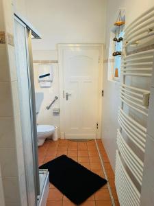 a bathroom with a toilet and a door with a rug at Troisdorf - City - EG - 145 Qm - bis 7 Schlafplätze in Troisdorf
