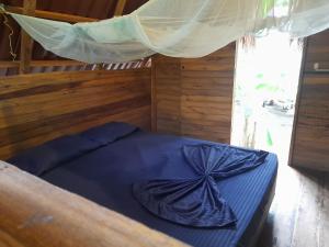 a bedroom with a blue bed with a mosquito net at La Playita in Guachaca
