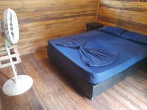a bedroom with a blue bed with a fan at La Playita in Guachaca