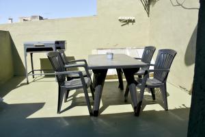 a table and chairs on a patio with a grill at Las Blanquitas- departamento en el centro de Chascomús, a pocos metros de la laguna in Chascomús