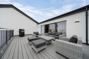 a deck with furniture and a grill on a house at BayView Luxury 3 Bedroom Apartment First Floor in Downings +5 photos